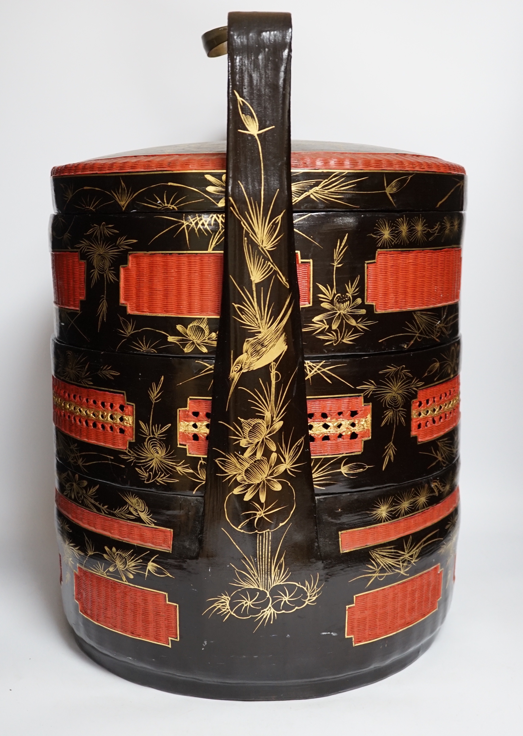 A Chinese three section lacquer wedding basket with gilded decoration